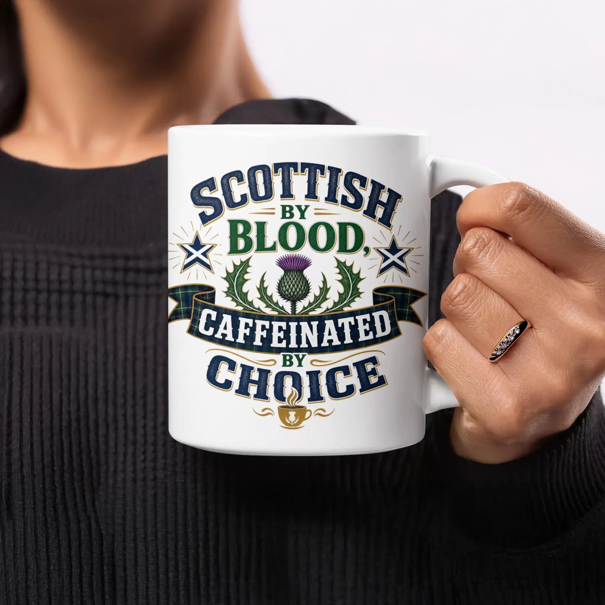 White mug with "SCOTTISH BY CAFFEINATED BY CHOICE" text and thistle design.