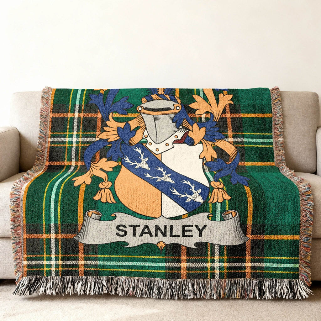 Stanley family crest on a green plaid woven throw blanket.