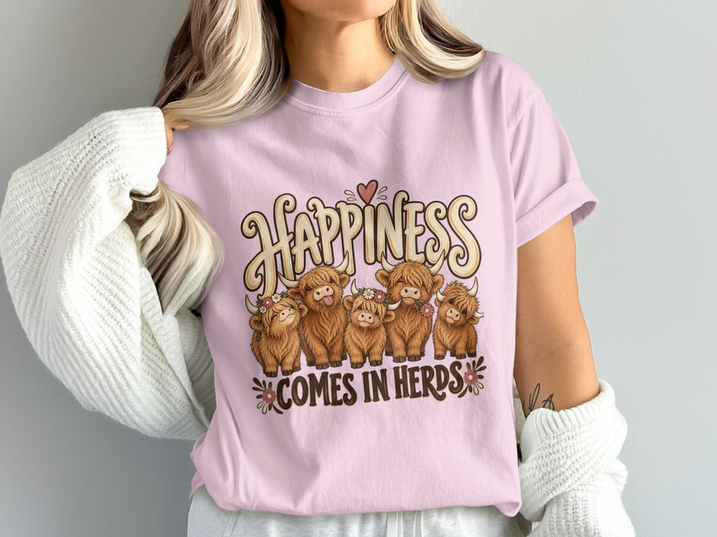 Model wearing the Happiness Comes in Herds Highland cow Comfort Colors T-shirt in Blossom