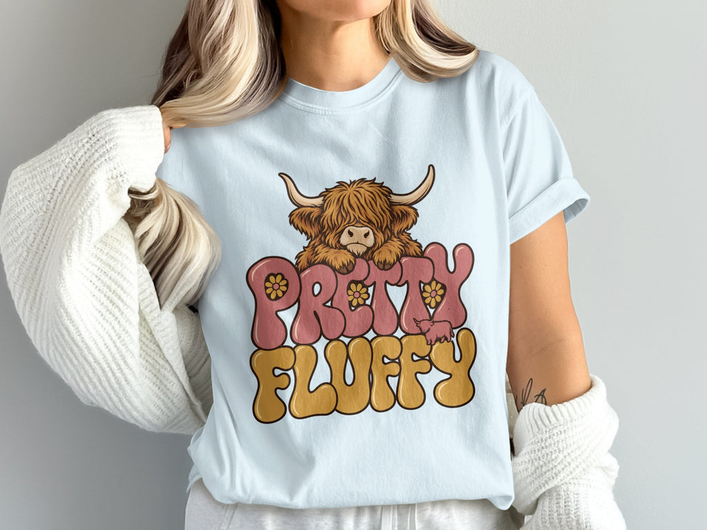 Model wearing the Pretty Fluffy Highland cow Comfort Colors T-shirt in Chambray