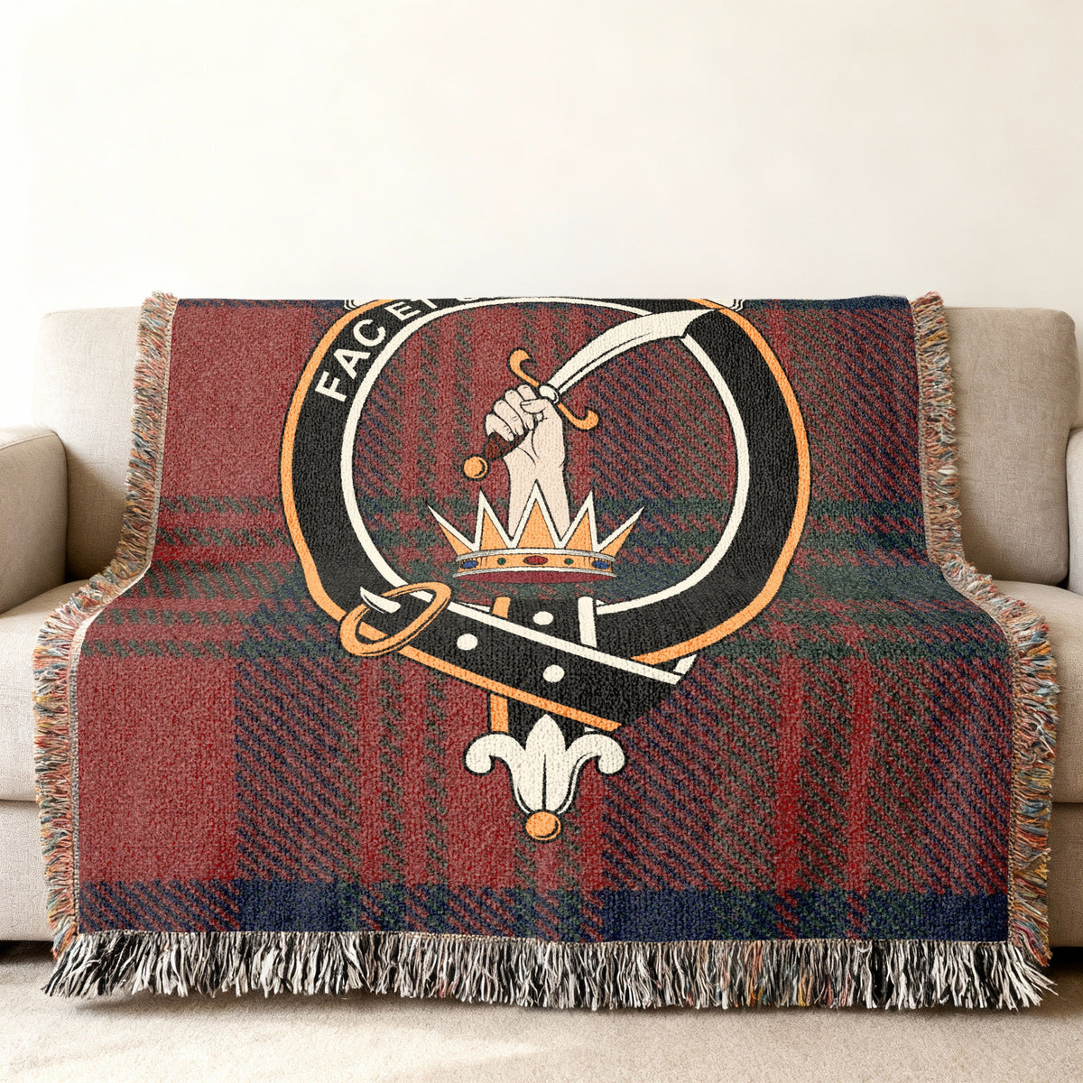 Close view of the Matheson woven blanket draped over a sofa, showing the crest and fringed edges