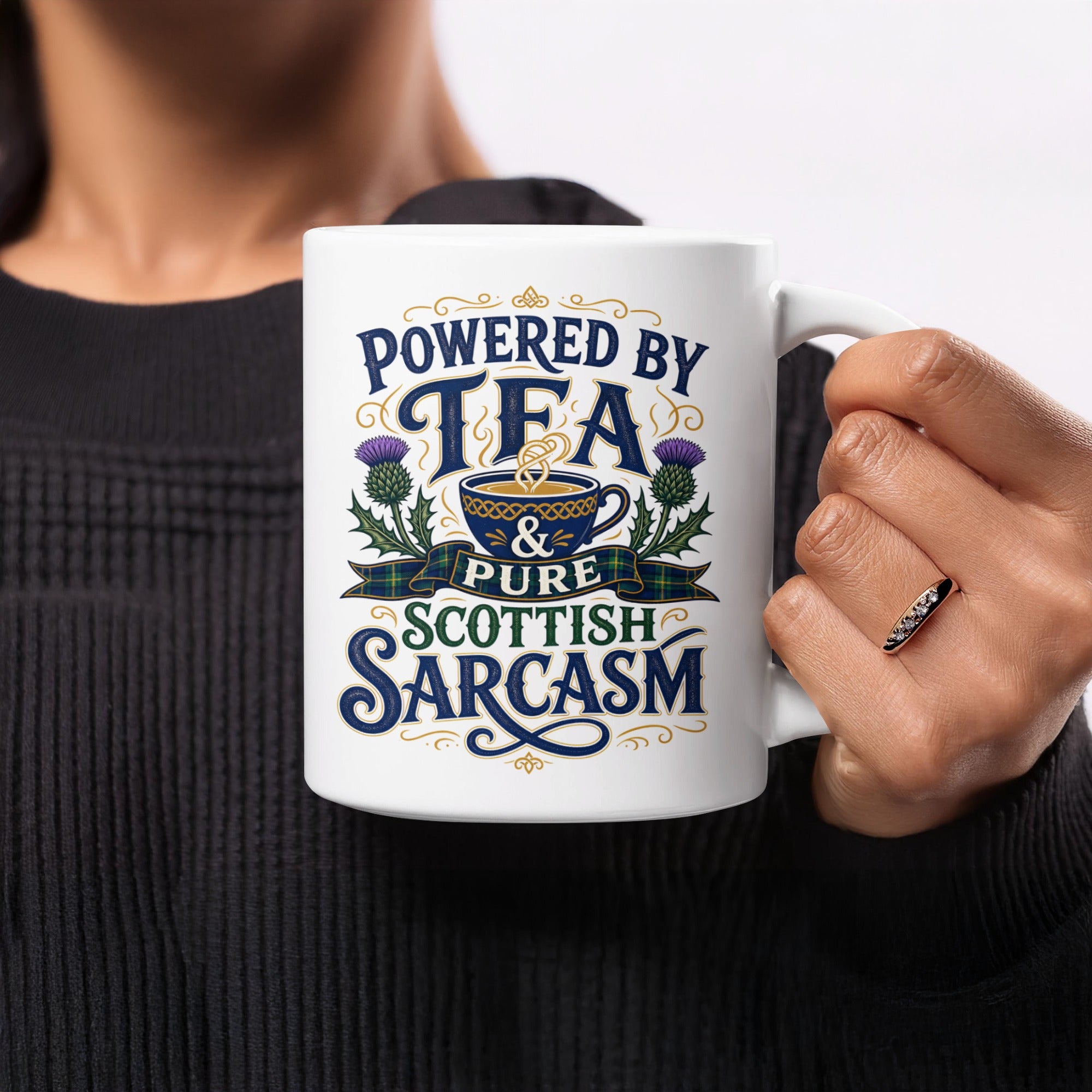 White mug with "Powered by tea and pure Scottish sarcasm" text and thistles.