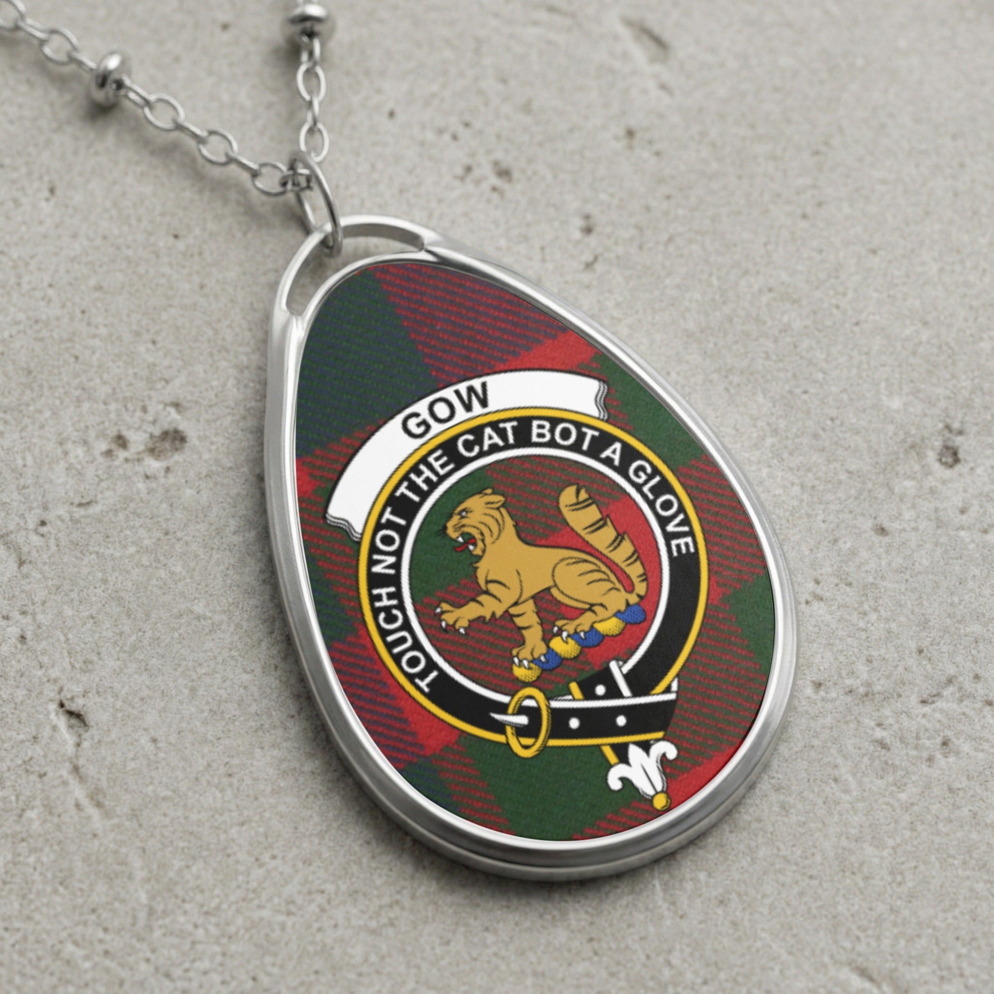 Gow clan Scottish tartan necklace with clan crest and Touch Not The Cat Bot A Glove motto on tartan background
