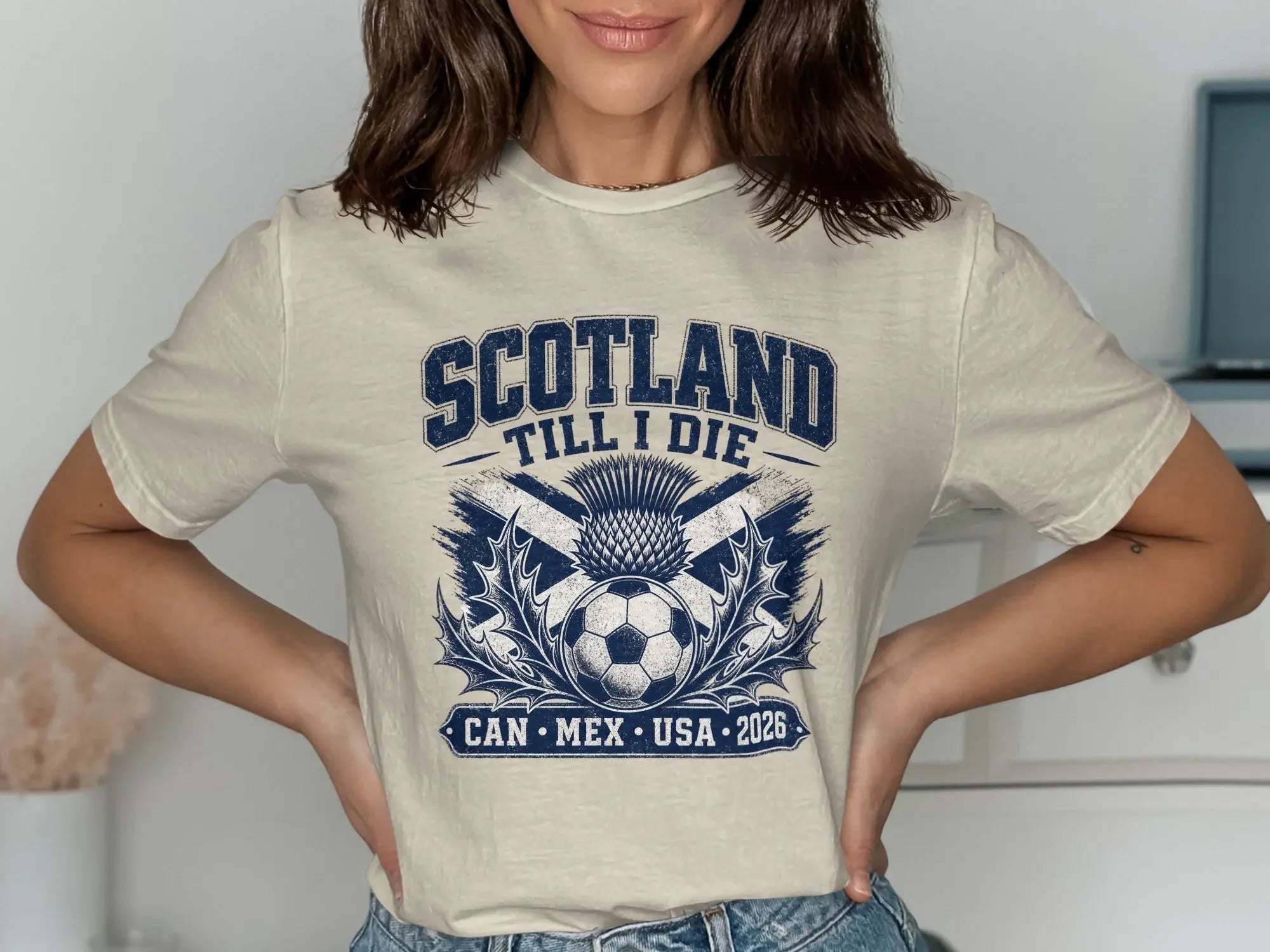 Cream t-shirt with Scotland Till I Die text, soccer ball, and thistle.