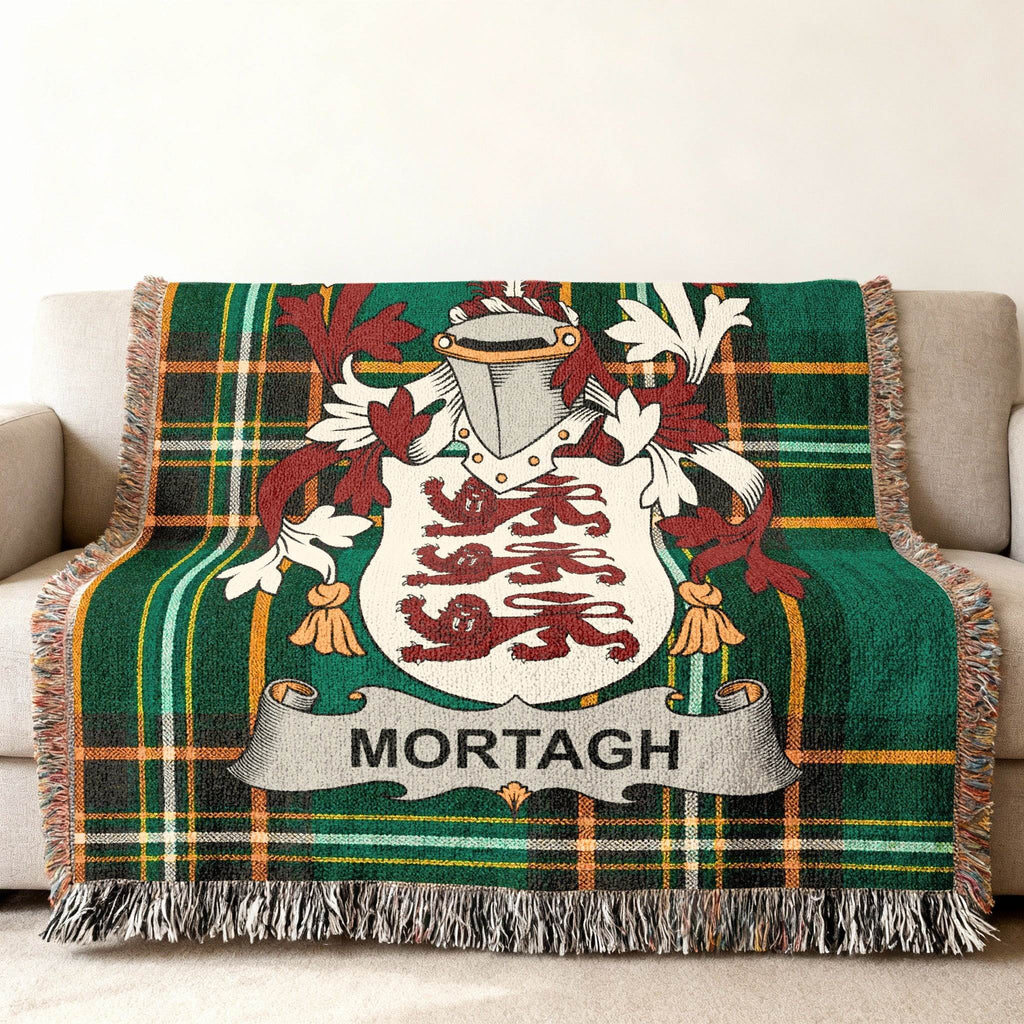 Green tartan blanket with Mortagh family crest draped on a sofa.