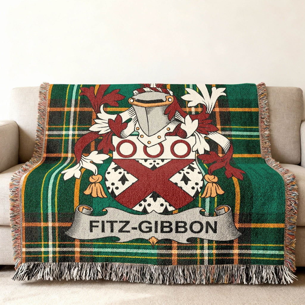 Green tartan blanket with Fitz-Gibbon family crest draped on a sofa.