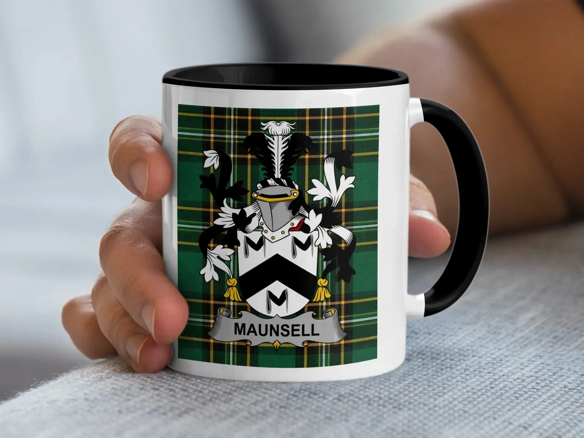 White mug with black rim featuring the Maunsell family crest on a tartan background.