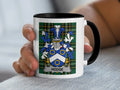 White mug with black rim featuring the Hodge family crest on a green tartan background.