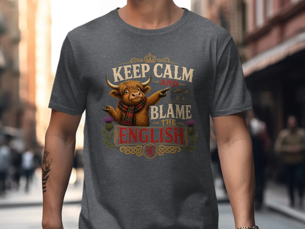 Dark grey t-shirt with "Keep Calm and Blame the English" text and highland cow graphic.