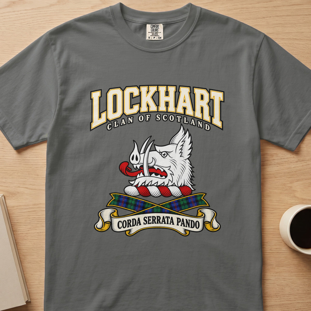 Lockhart white boar’s head and tartan ribbons graphic on a charcoal gray Comfort Colors T-shirt, front view