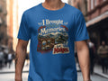 Blue t-shirt graphic: "I Brought Home Memories. And Midges." with suitcase and Scottish landmarks.