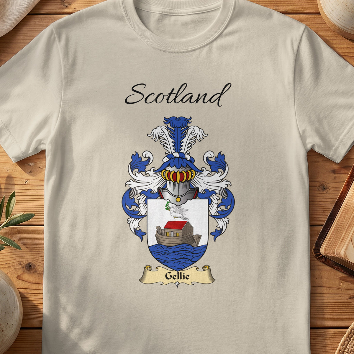 Sand Gellie Scottish family shield T-shirt featuring a boat on blue waves beneath a pale sky