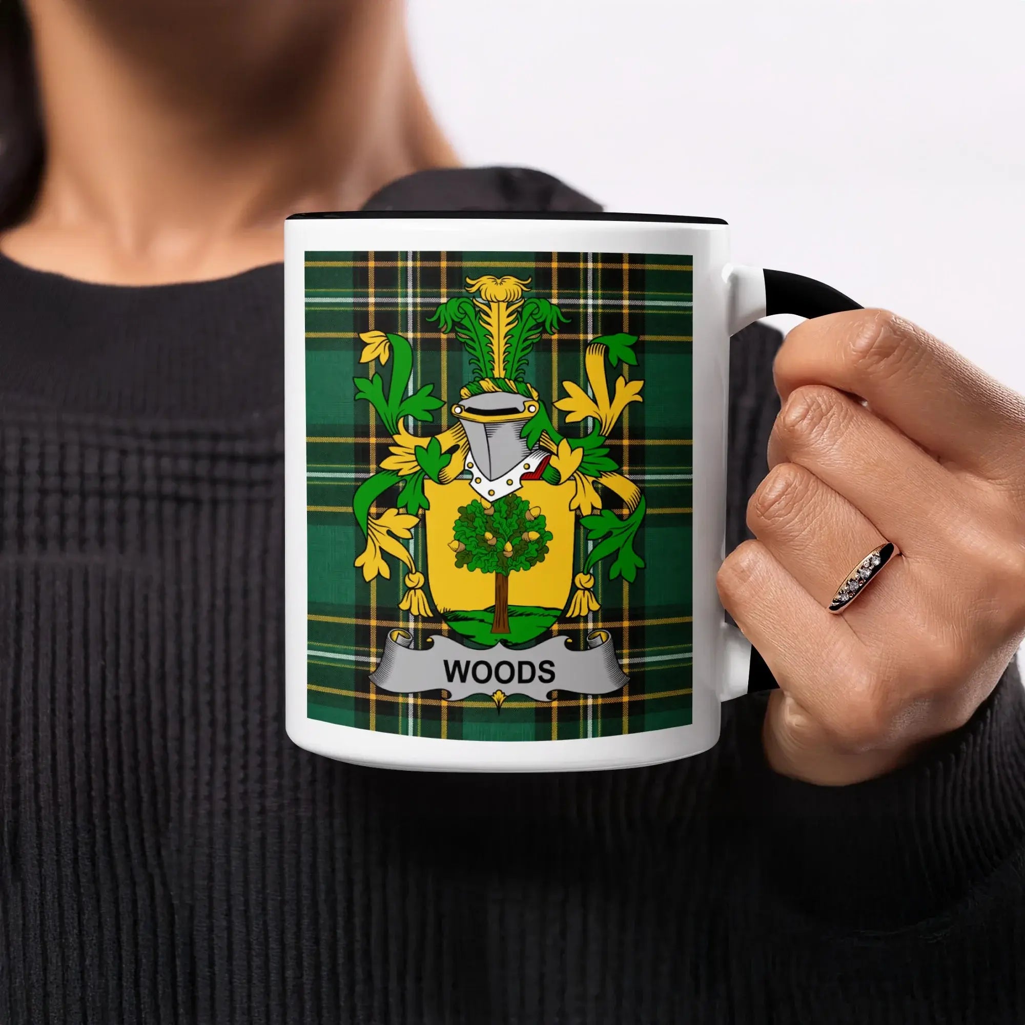White mug with black rim featuring the Woods family crest on a green plaid background.