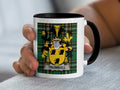 White mug with black rim displaying a Scottish tartan pattern and the Trumbull coat of arms.
