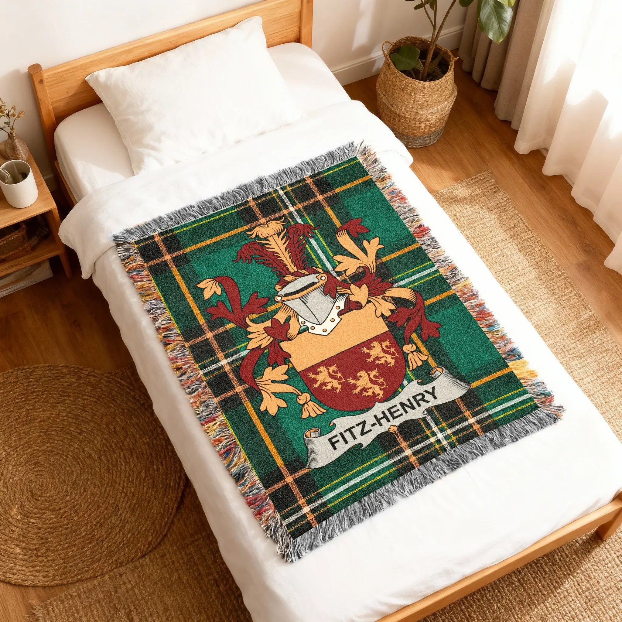 Green tartan woven blanket with Fitz-Henry family crest on a bed.