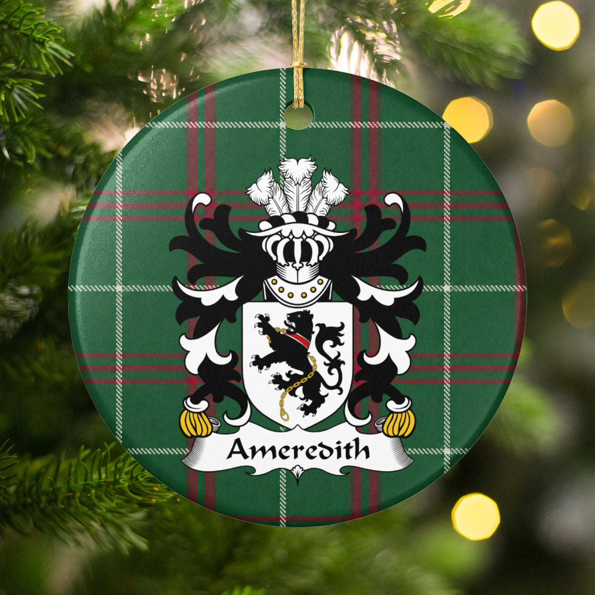 Ameredith family crest and surname on a round Welsh national tartan ornament, hanging by a gold cord among Christmas tree branches and warm golden lights.