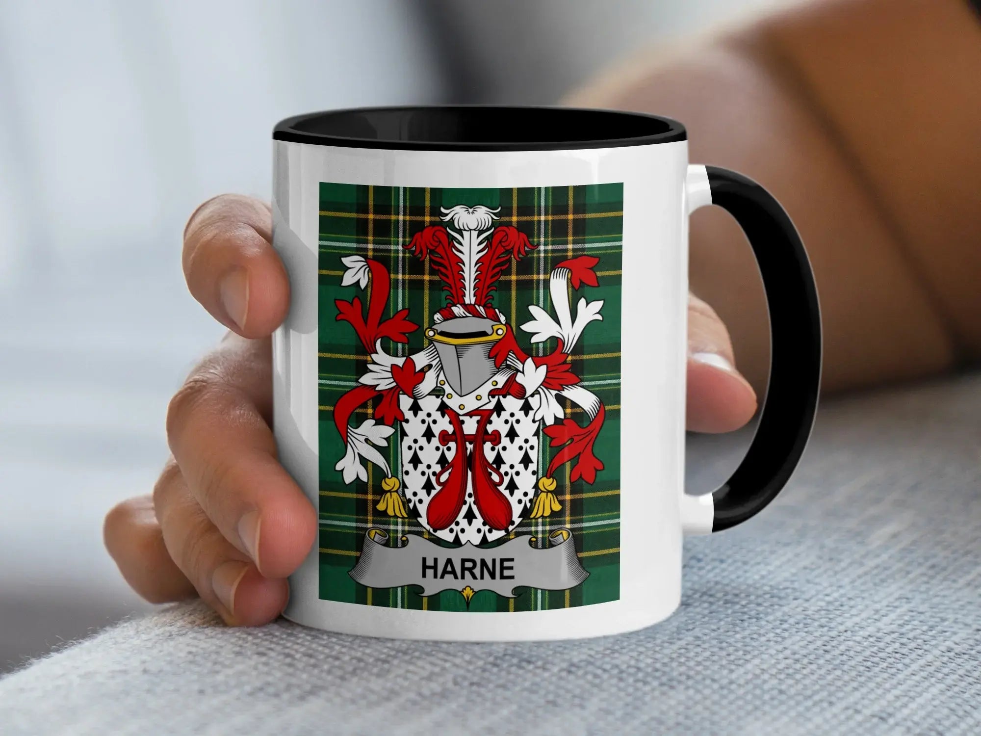 White mug with black rim featuring Harne family crest on green tartan background.