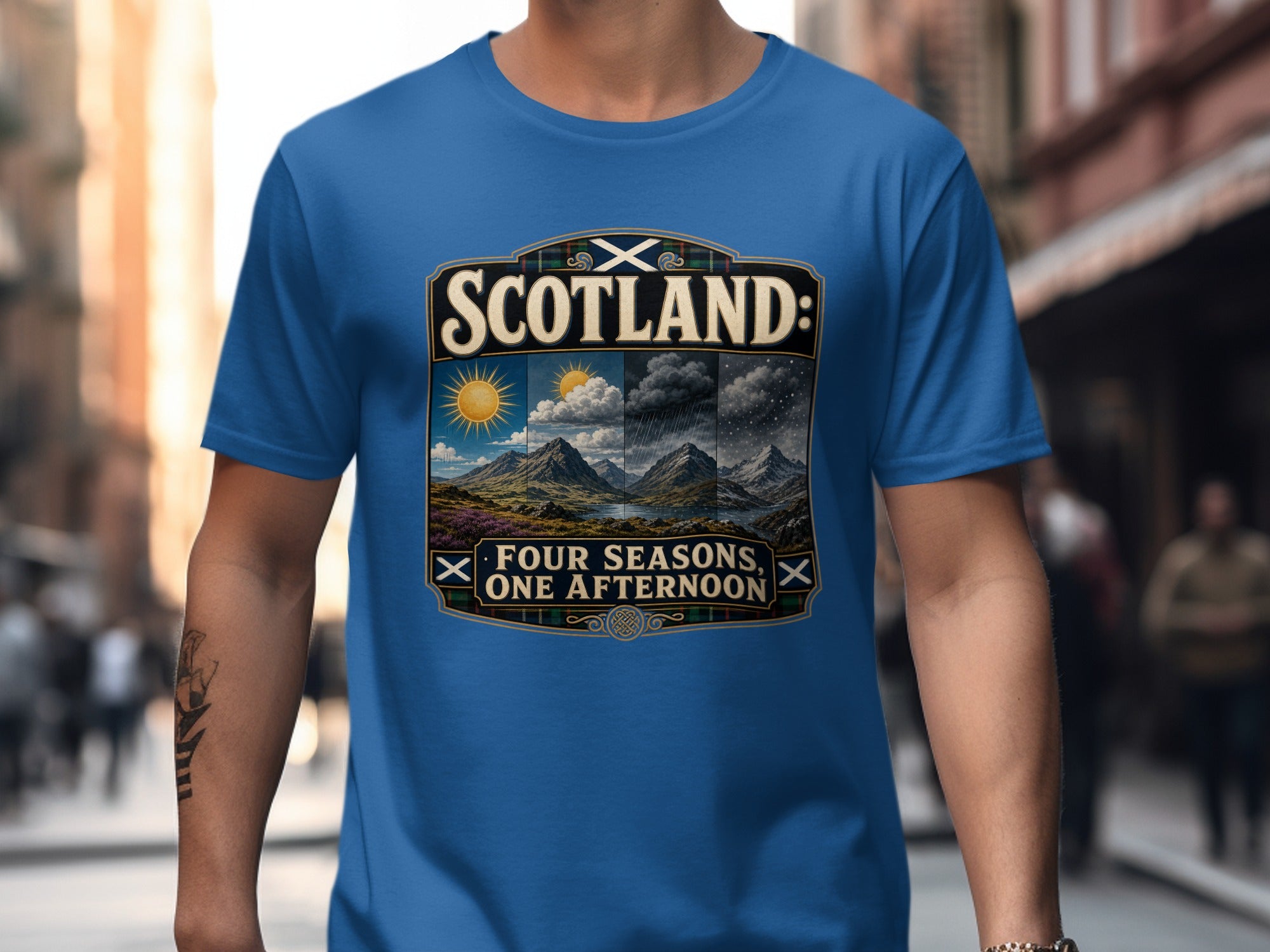 Blue t-shirt with "Scotland: Four Seasons, One Afternoon" graphic and landscape.