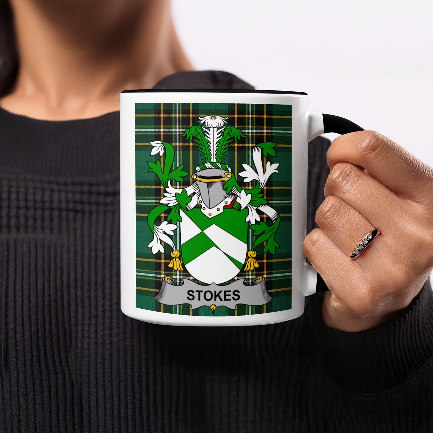 White mug with black rim featuring the Stokes family crest on a tartan background.