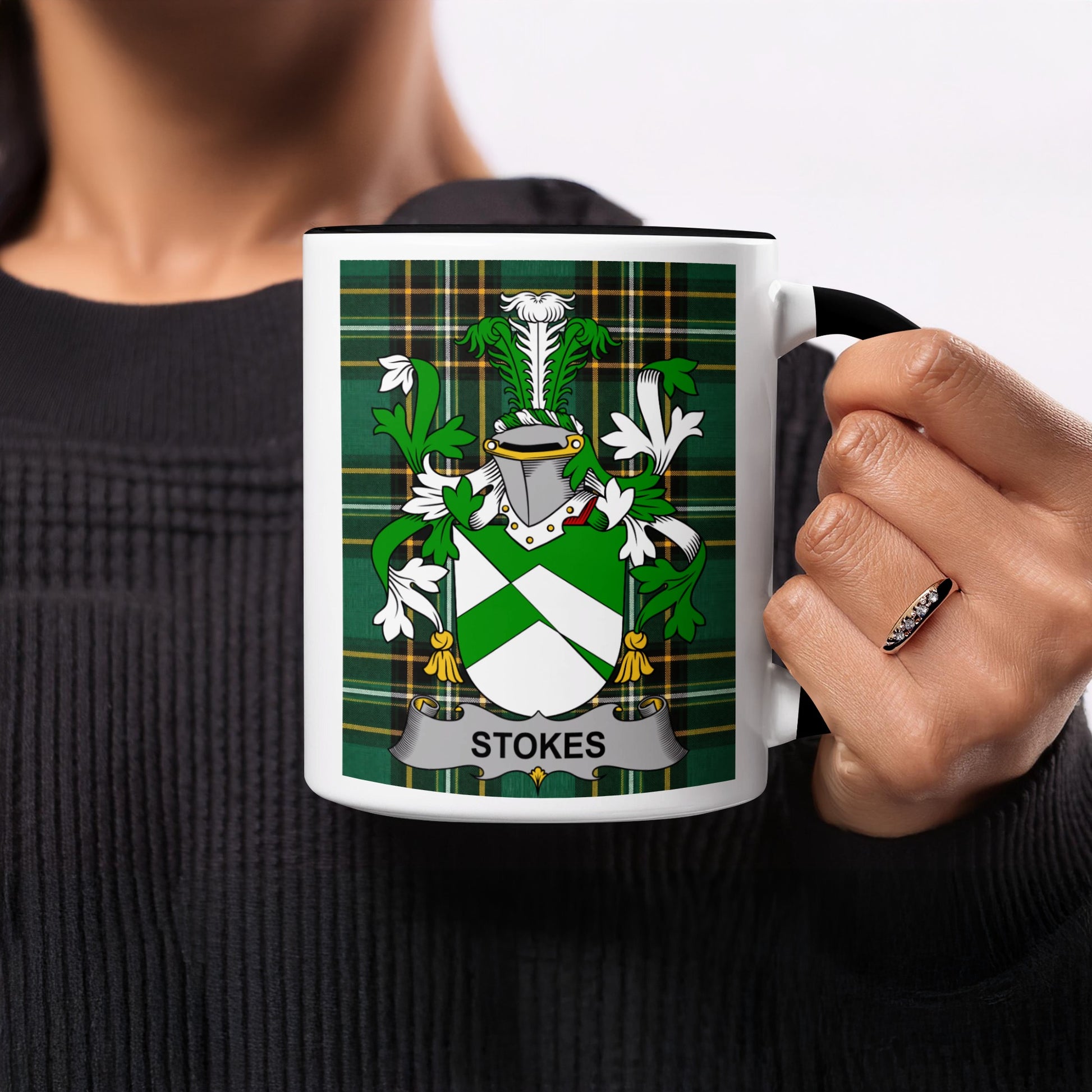 White mug with black rim featuring the Stokes family crest on a tartan background.