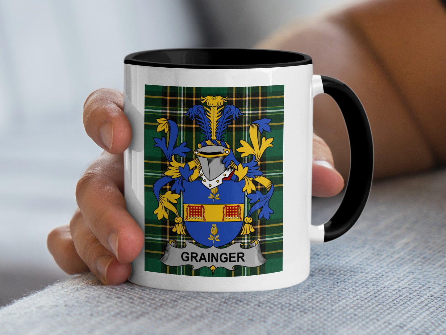 White mug with black rim featuring the Grainger family crest on a tartan background.