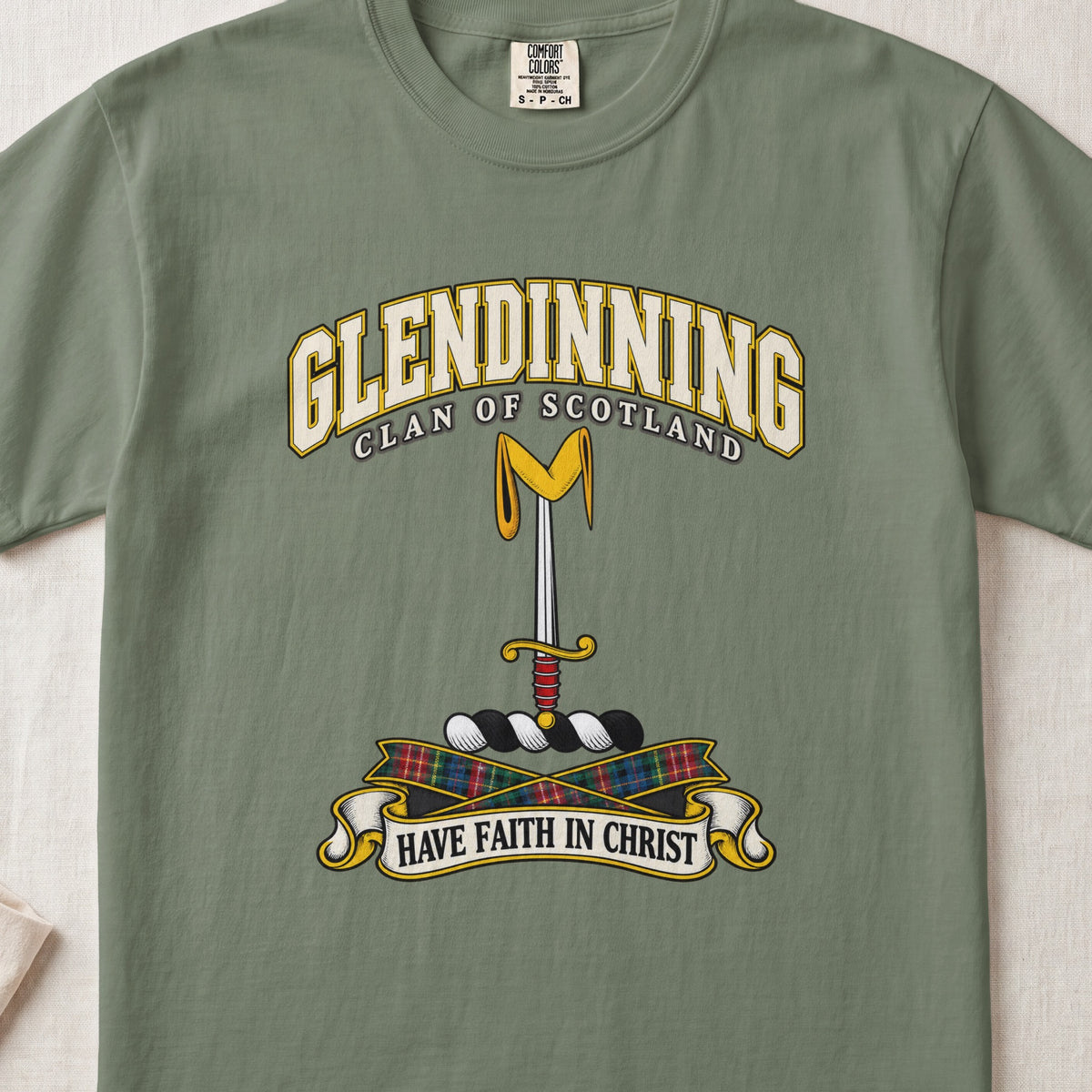 Glendinning Scottish clan T-shirt in Moss, front view with an upright sword beneath a gold pennon and motto design.