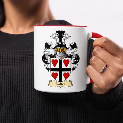 White mug with red handle, featuring the Butter family crest and a gold banner.