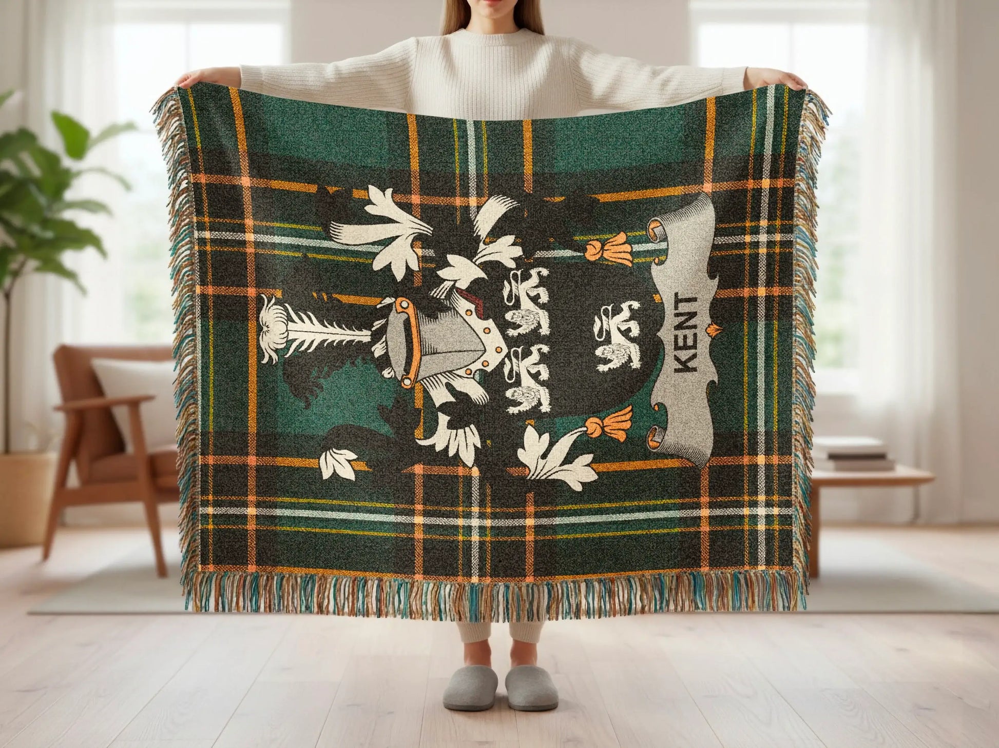 Tartan blanket with crest and "KENT" text held by a person.