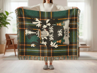 Tartan blanket with crest and "KENT" text held by a person.