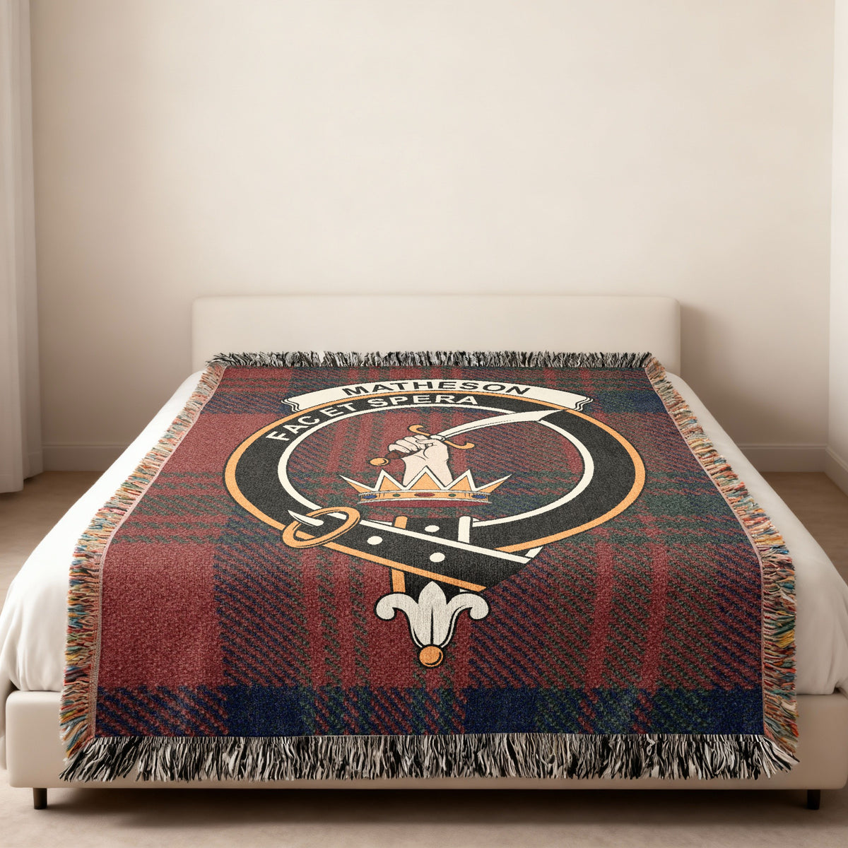 Matheson Scottish woven blanket spread across a bed, showing the full crest design and tartan background