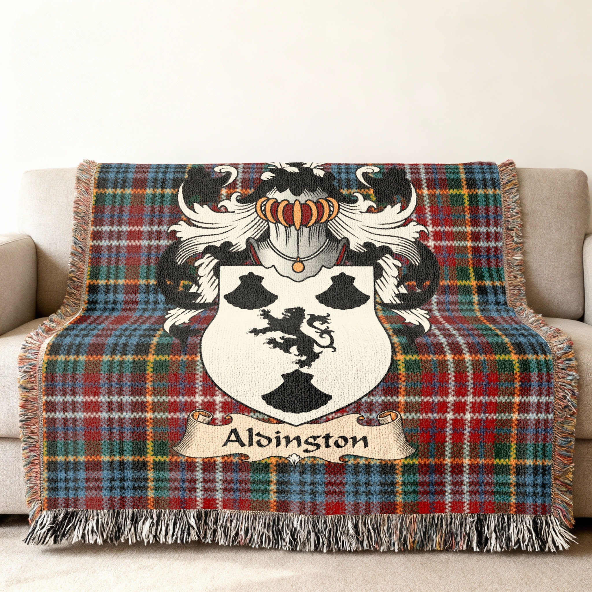 Alsington Scottish family shield woven blanket with Caledonia tartan background on a sofa