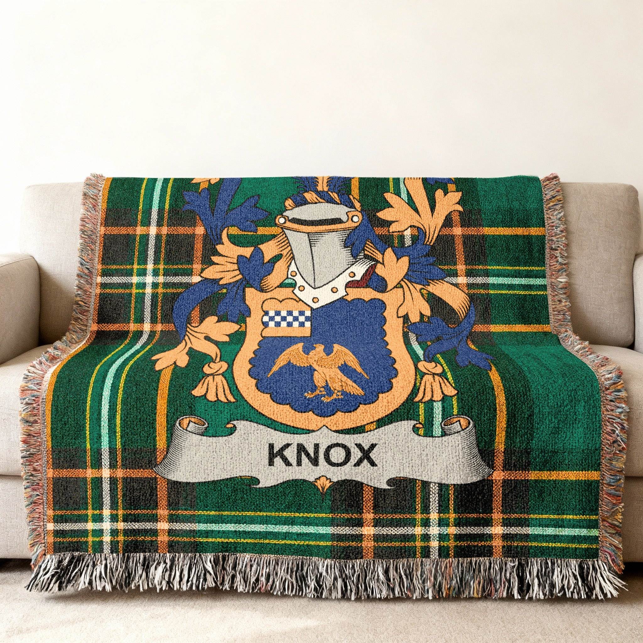 Green tartan blanket with a shield featuring a bird and the name KNOX.