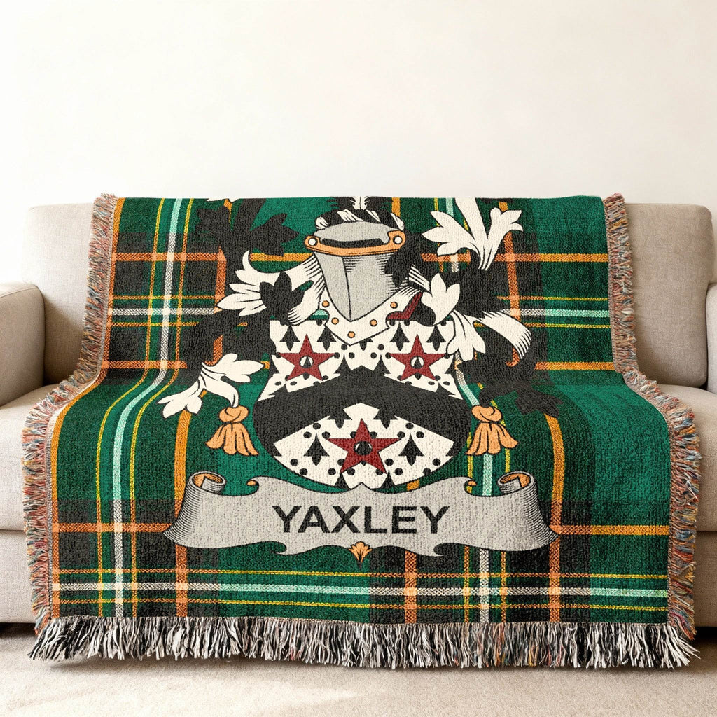 Tartan throw blanket with Yaxley family crest on a sofa.
