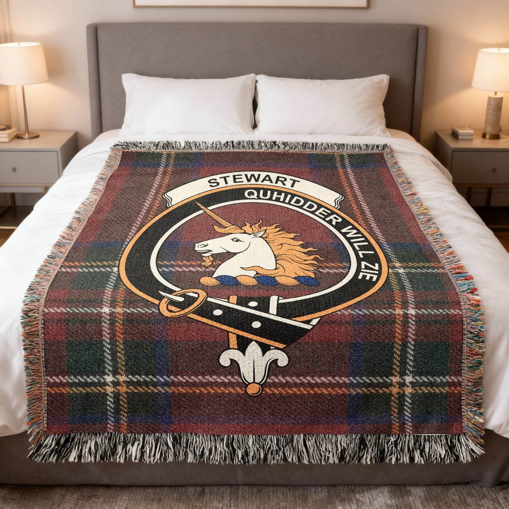 Stewart of Appin woven blanket displayed on a bed, with a white unicorn's head with a golden mane on a red, green and blue tartan background
