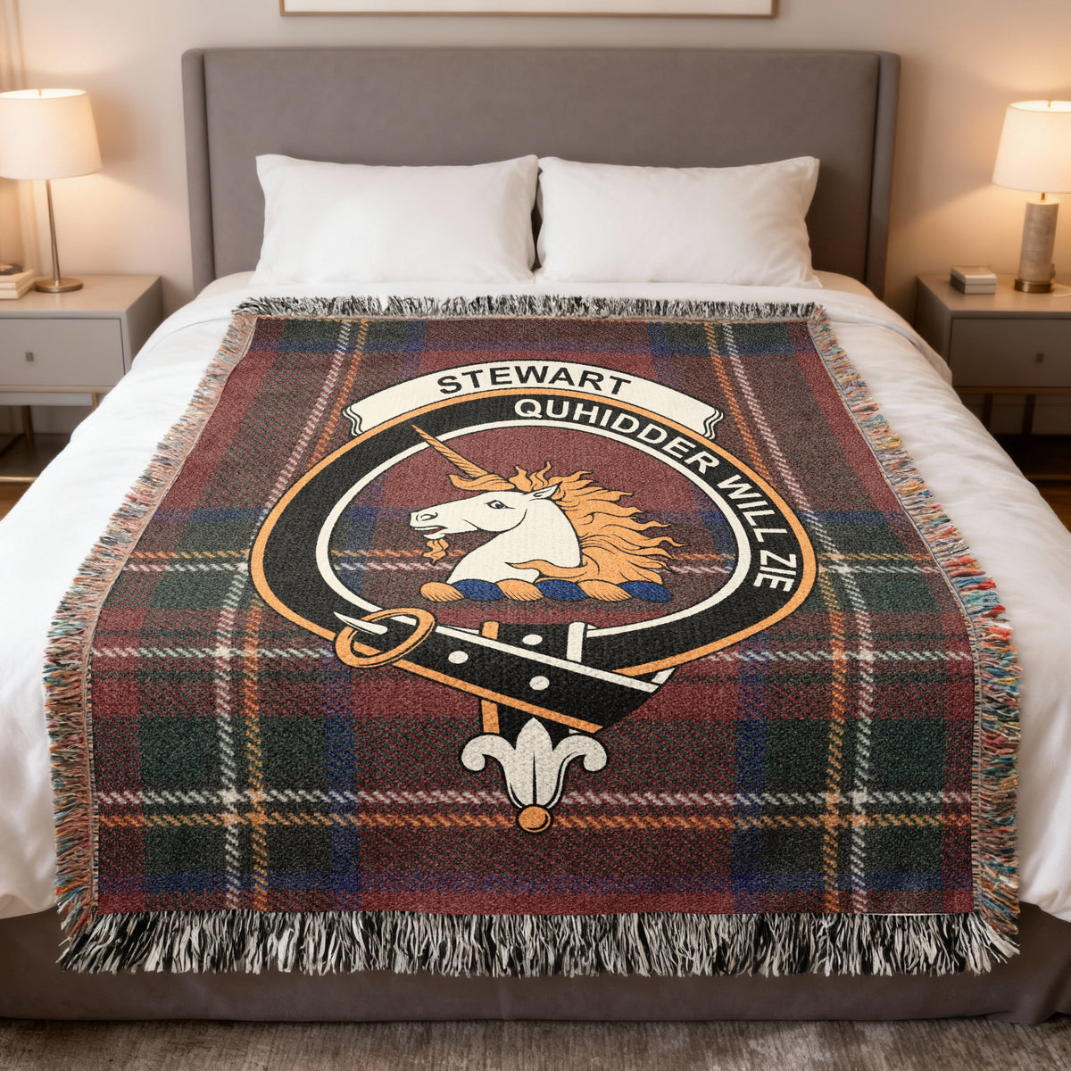 Stewart of Appin woven blanket displayed on a bed, with a white unicorn's head with a golden mane on a red, green and blue tartan background