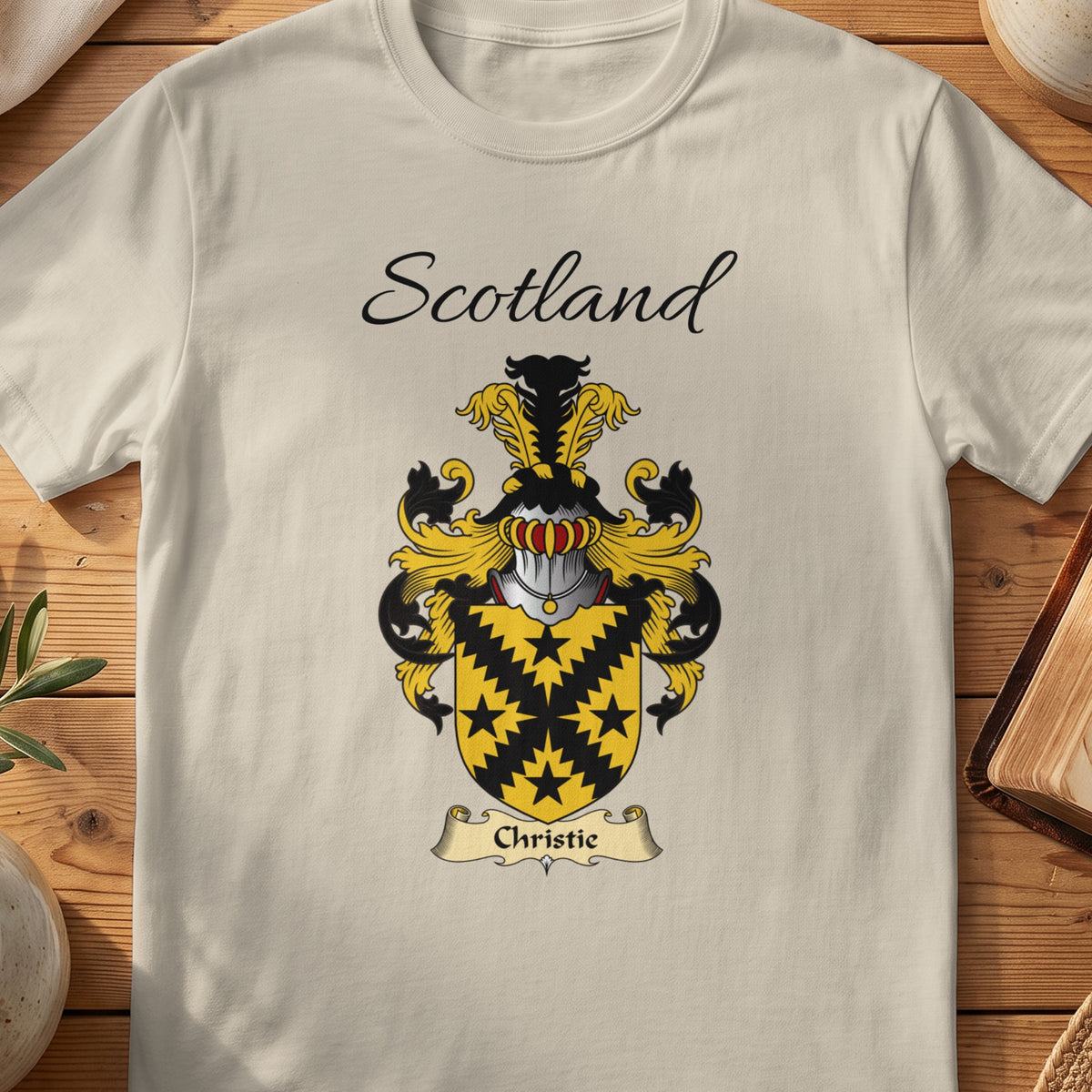 Sand Christie Scottish family shield T-shirt featuring a black jagged diagonal cross and star motifs on gold