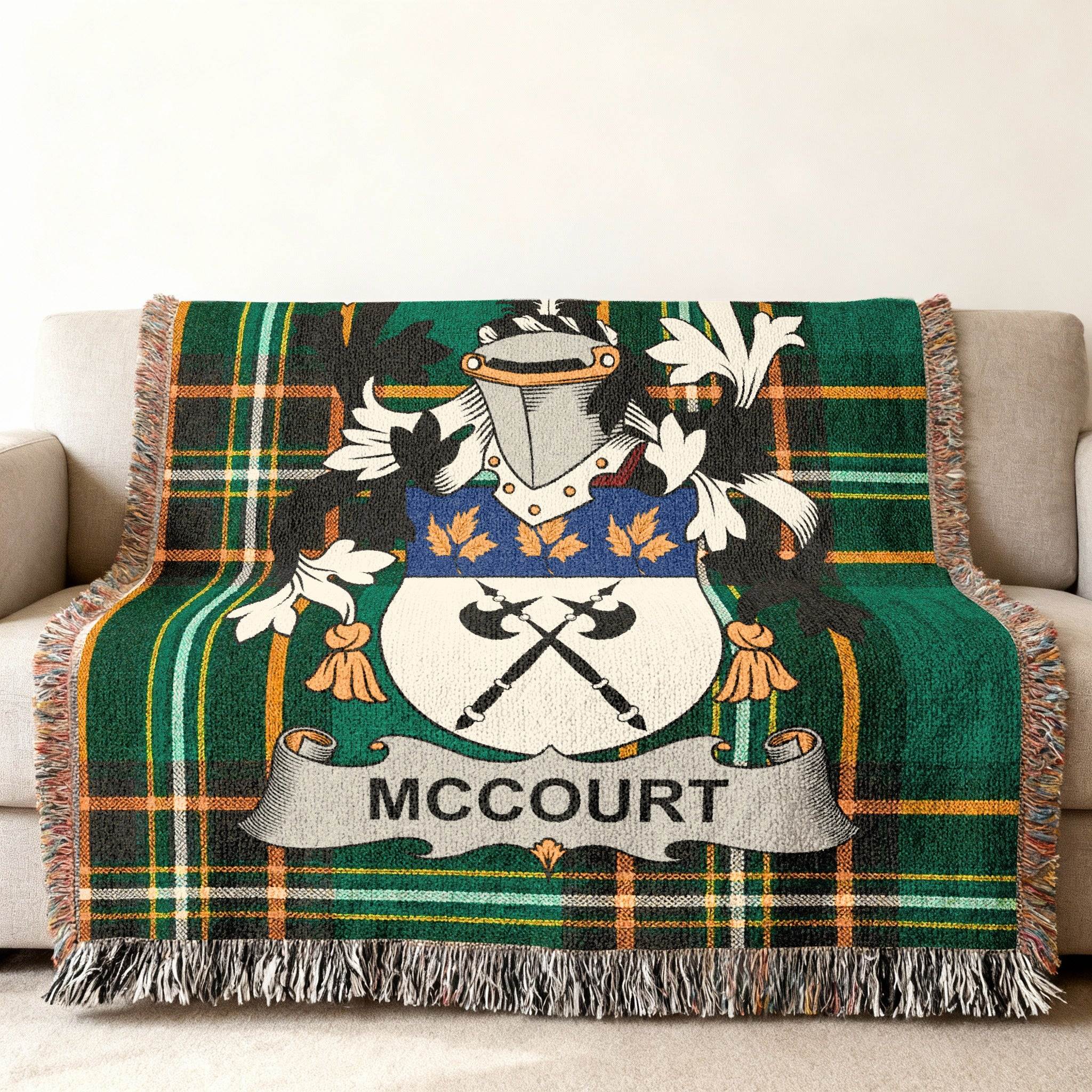 Green tartan throw blanket featuring McCourt family crest with crossed axes.