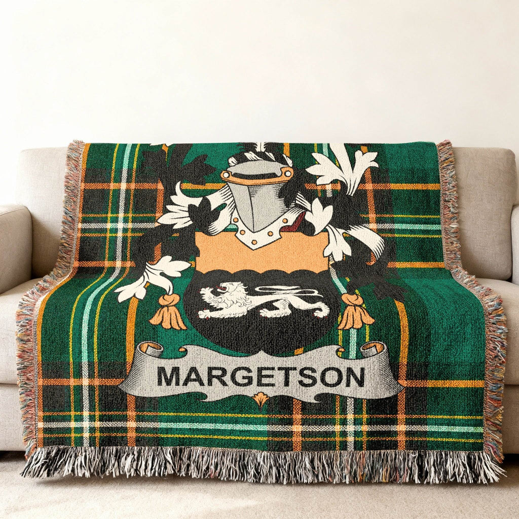 Green tartan blanket with MARGETSON family crest draped on a sofa.