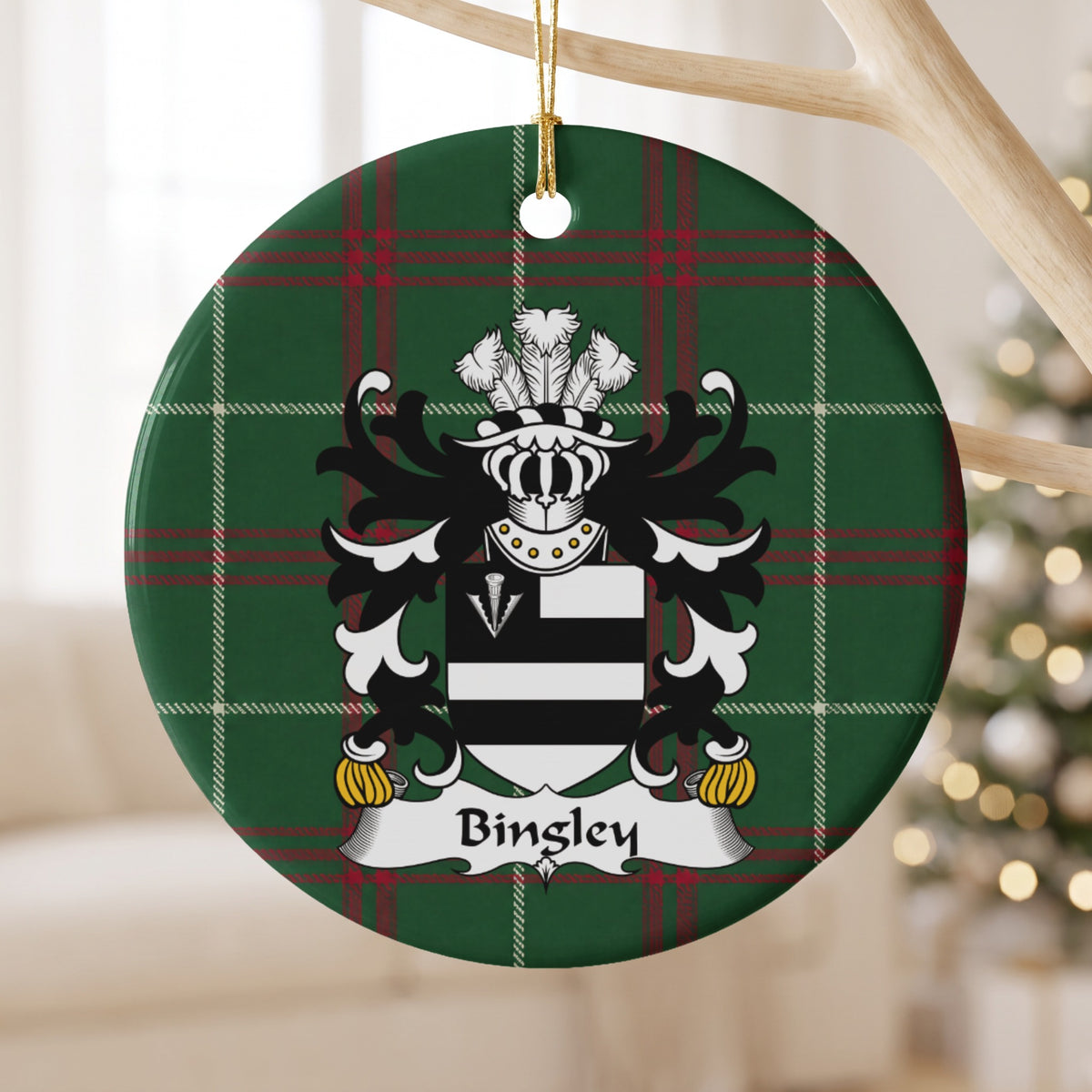 Bingley ornament hanging from a pale wooden branch; two black bars on white with a white arrowhead in a black corner panel on Welsh national tartan.