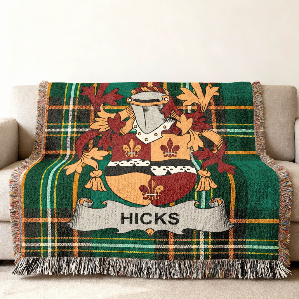 Green plaid throw blanket with Hicks family crest featuring shield and helmet.
