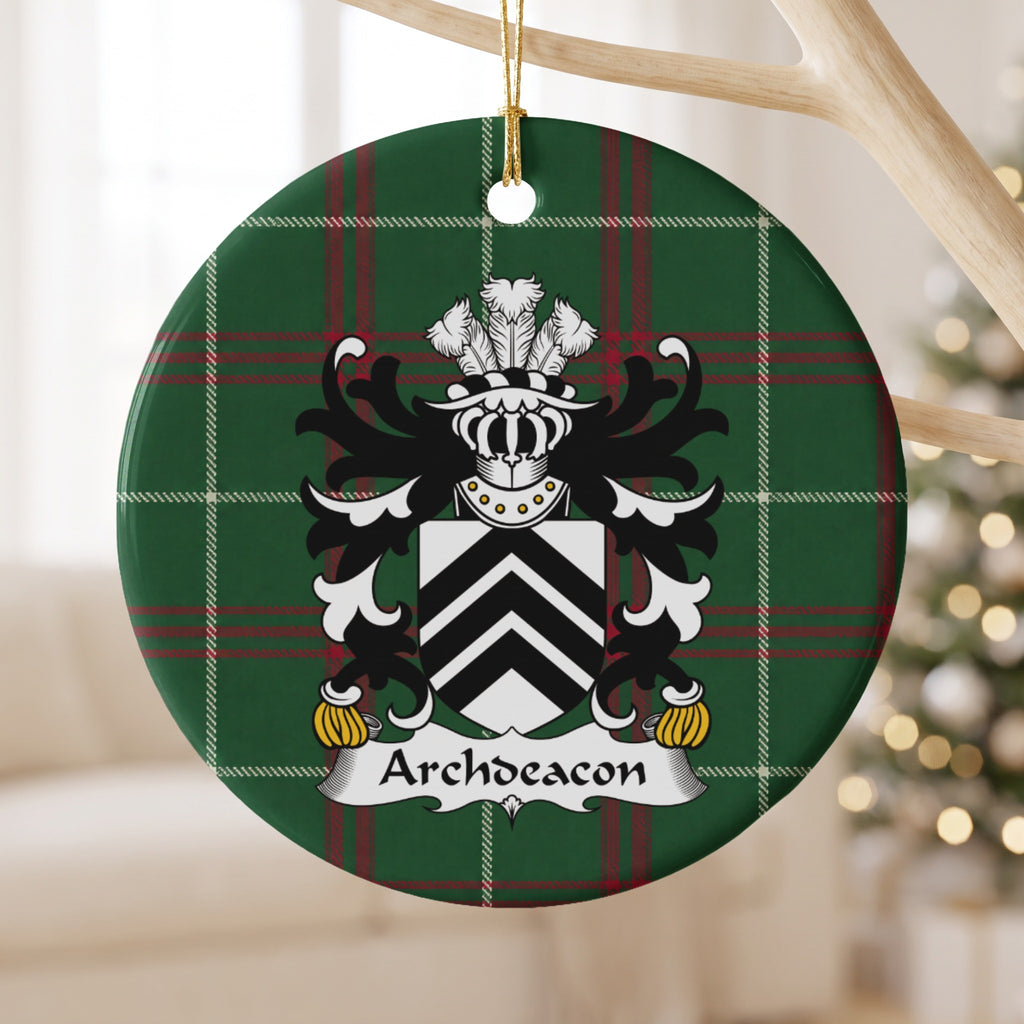 Archdeacon family crest and surname on a round Welsh national tartan ornament, hanging by a gold cord from a pale wooden branch with blurred Christmas lights behind it.