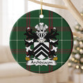 Archdeacon family crest and surname on a round Welsh national tartan ornament, hanging by a gold cord from a pale wooden branch with blurred Christmas lights behind it.