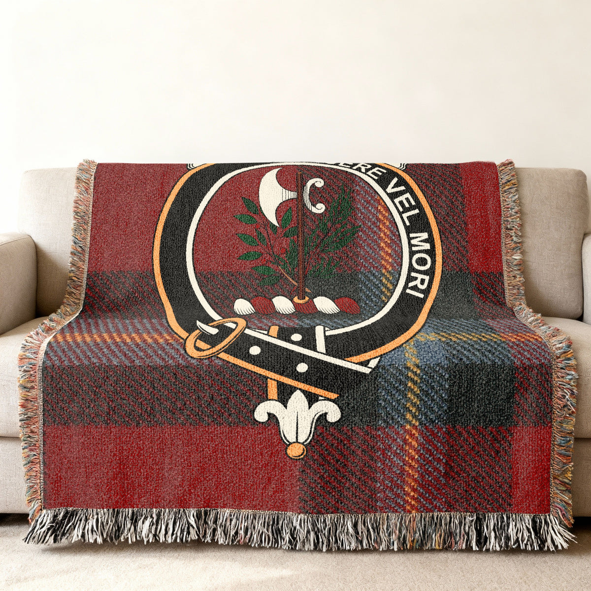 Close view of the MacLaine of Lochbuie woven blanket draped over a sofa, showing the crest and fringed edges