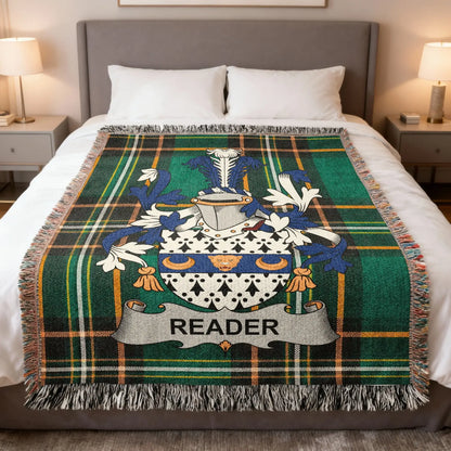 Tartan blanket with Reader family crest on a bed.