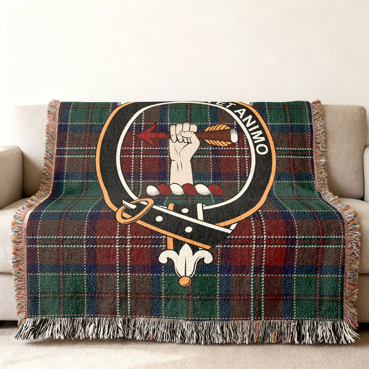 Close view of the MacCulloch woven blanket draped over a sofa, showing the crest and fringed edges