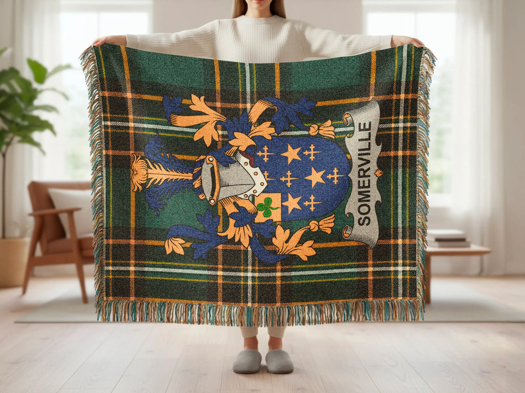 Tartan blanket with Somerville crest held by person in living room.