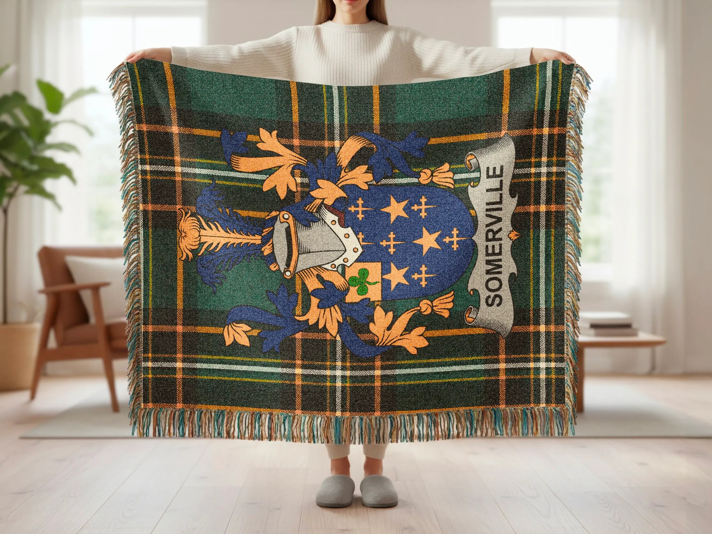 Tartan blanket with Somerville crest held by person in living room.