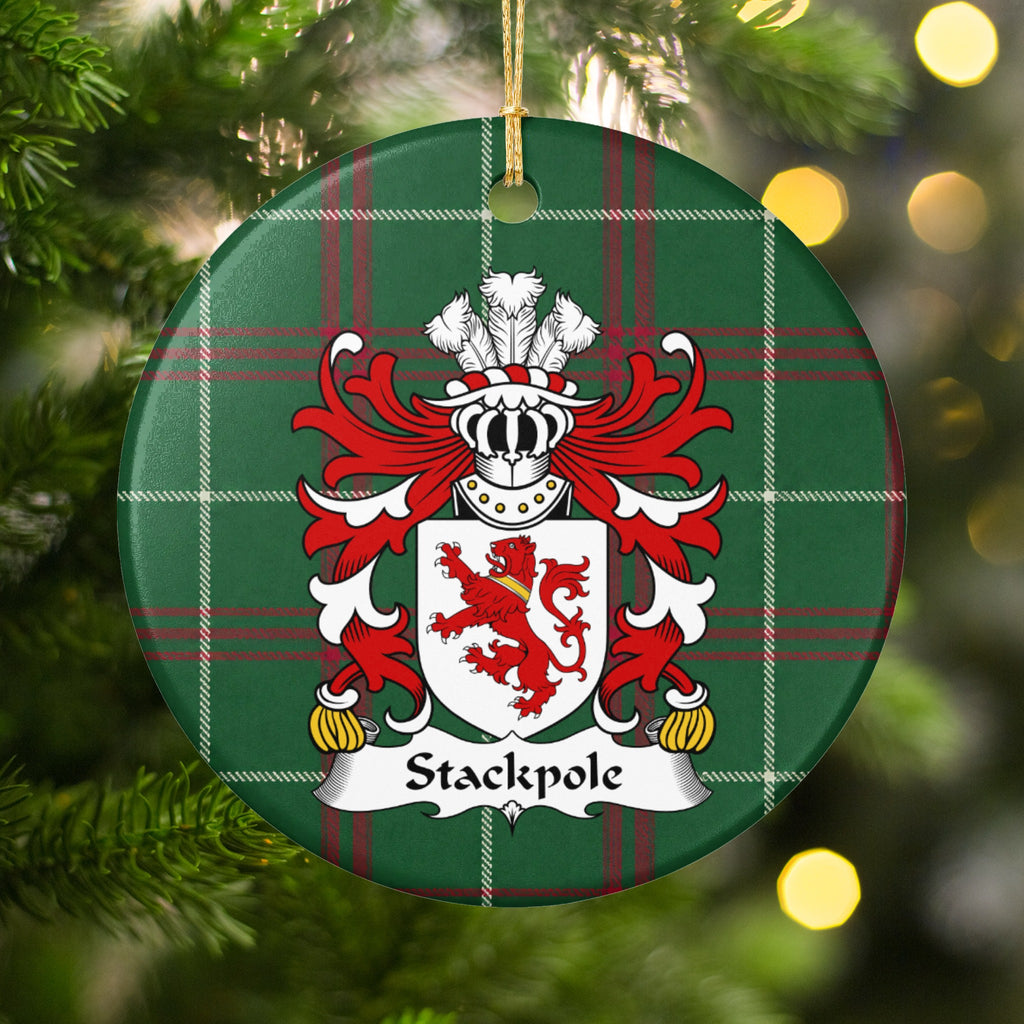 Stackpole family crest ornament with Welsh national tartan background, hanging by a gold cord among Christmas tree branches and warm lights.