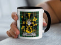 White mug with black rim featuring a green tartan pattern and the Giles family crest.