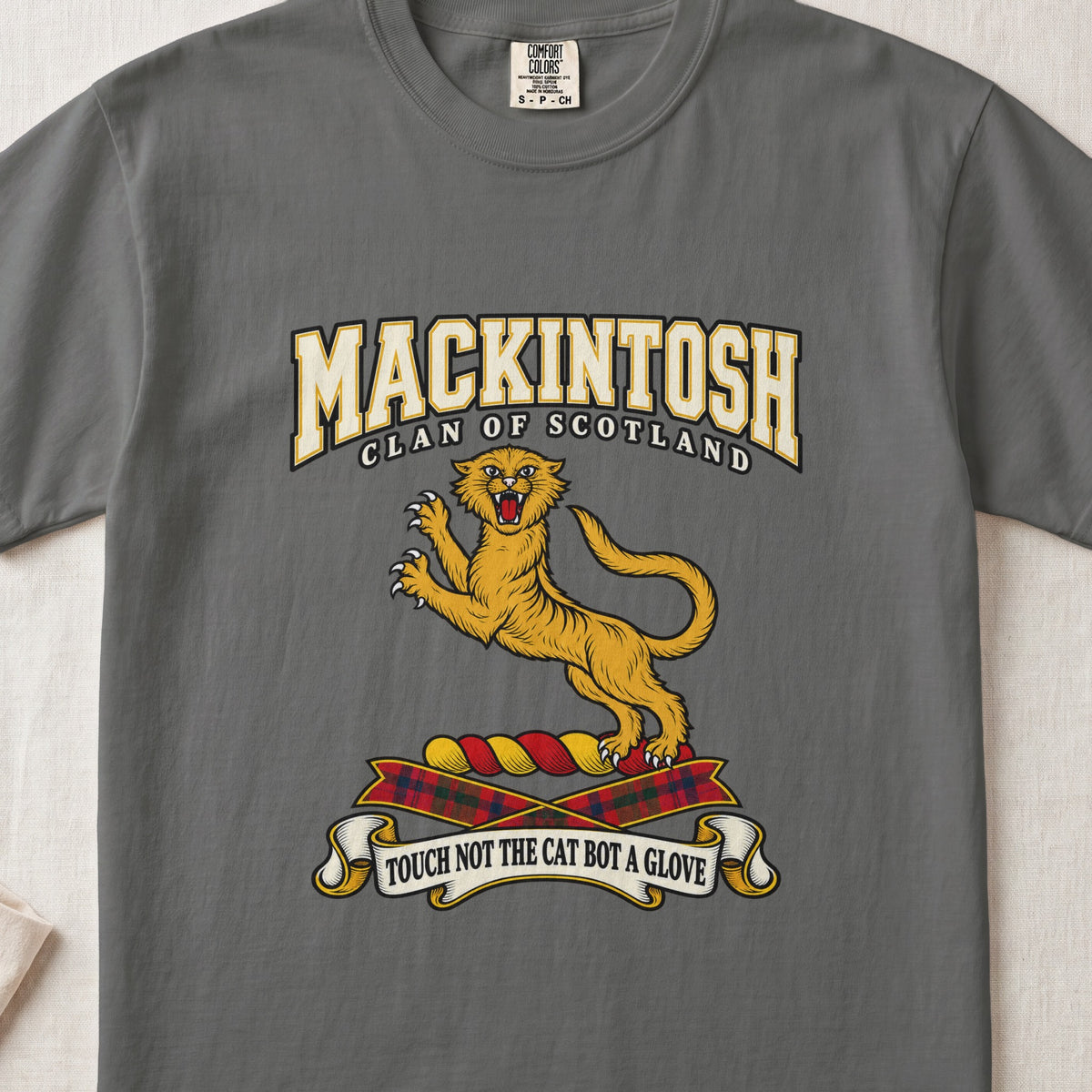 MacKintosh graphic T-shirt in Pepper gray, front flat lay showing varsity lettering and gold leaping wildcat with raised claws and open mouth.